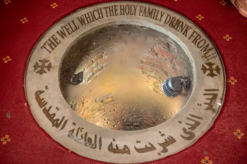 Runder Brunnenschacht unter Glas mit der Inschrift: The well which the Holy Family drank from