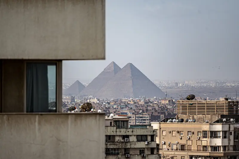 Die Pyramiden von Gizeh hinter den Dächern der Stadt, gesehen von einem Hotelbalkon