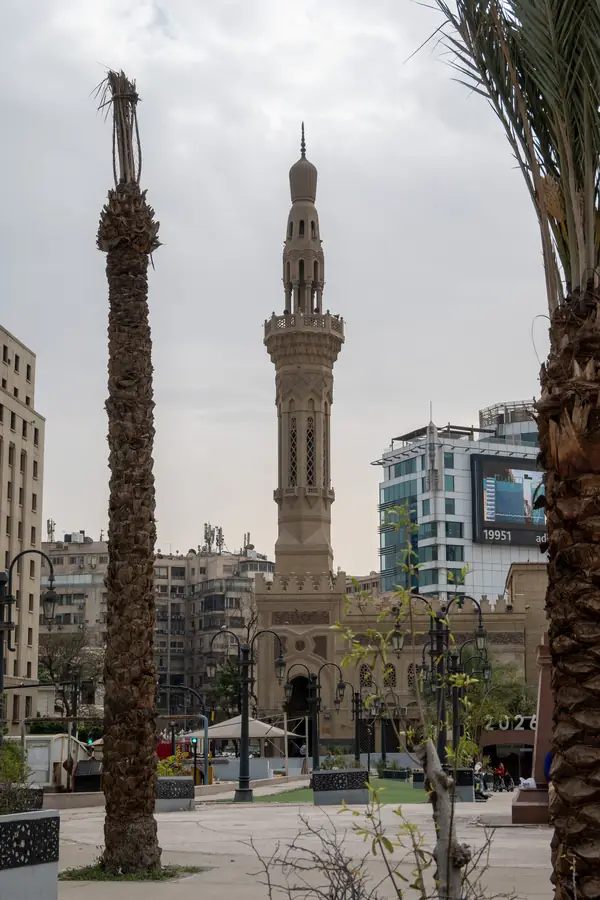Minarett zwischen zwei Palmenstämmen in Kairo