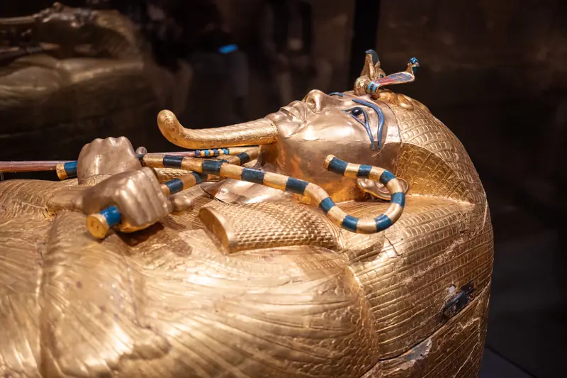 Detail eines goldenen Sarges mit gekreuzten Armen, Krummstab und Geißel