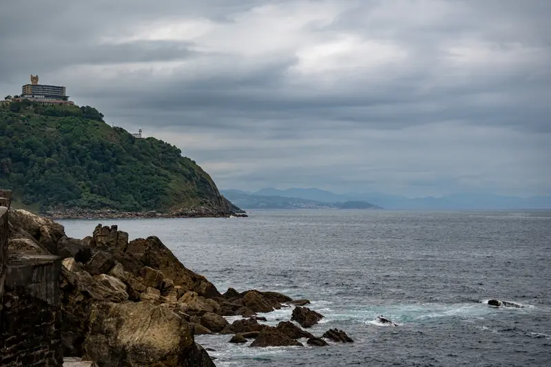 Felsige Küste bei San Sebastián unter dunklen Wolken