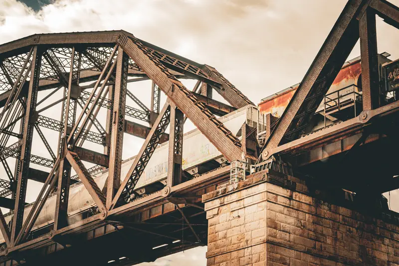 Stählerne Fachwerkbrücke, darüber fährt ein Güterzug
