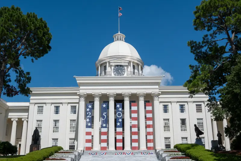 Das weiße Kapitol von Alabama mit großen 250-Bannern in den Landesfarben